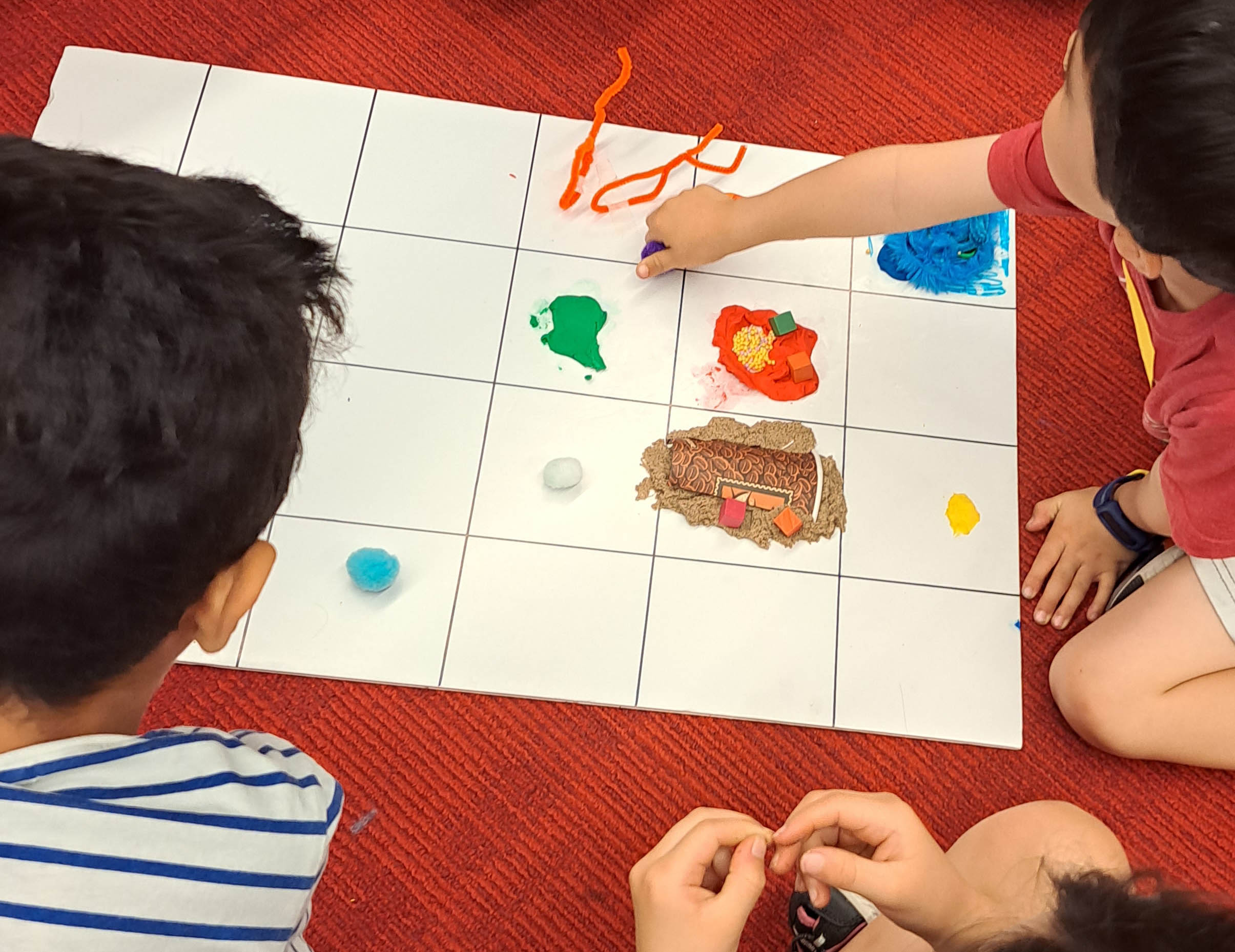 Child sharing their creation on foam board.